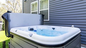 A hot tub next to a house with a window. - 5BR New Buffalo Home, Hot Tub, Fire Pit, Near Downtown (New Buffalo)