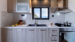 A modern kitchen with a sink, stove, oven, and cabinets.