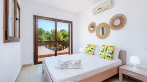 Una camera da letto con un letto, un comodino, una finestra vista e un condizionatore d'aria a parete.