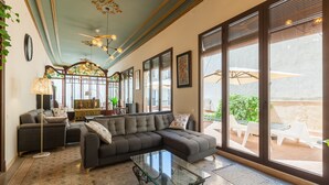 A living room with a sectional sofa, a glass coffee table, and a view to an outdoor patio with chairs. - Holiday Home 'Apartament Xarello' with Terraces (Vilafranca del Penedes)