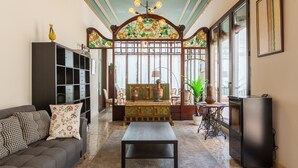 A living room with a sofa, a coffee table, a bookshelf, a decorative cabinet, and a television. - Holiday Home 'Apartament Xarello' with Terraces (Vilafranca del Penedes)