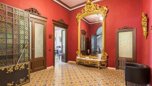 A room with a patterned floor, a large ornate mirror, and a black chair. - Holiday Home 'Apartament Xarello' with Terraces (Vilafranca del Penedes)