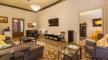 A living room with a sofa, coffee table, TV, and patterned flooring.