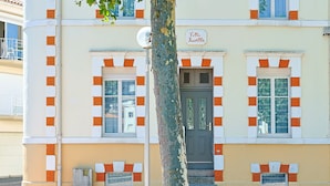 Un edificio con un letrero que dice 'Villa Rosella', con una puerta, ventanas y una pequeña entrada con escalones.