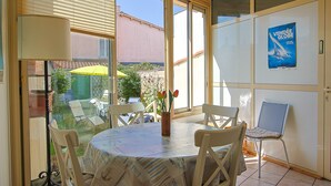 Comedor con mesa, sillas y vistas a través de un ventanal.