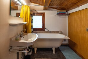 Un baño con bañera, lavamanos y espejo.