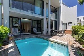 Un hôtel moderne doté d’une piscine, d’un espace extérieur aménagé et d’un patio couvert.