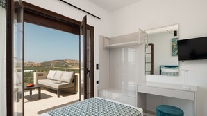 A modern hotel room with a balcony, a bed, a sofa, a TV, and a bathroom. - Anema Villa, a picture-perfect summer escape (Rethymno)