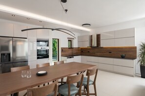 Eine moderne Küche mit einem Holzespeisetisch, Stühlen und integrierten Geräten.