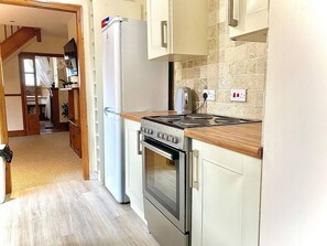 A kitchen with a stove, oven, and refrigerator.