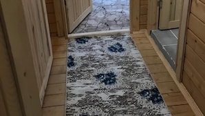 Ein schmaler Korridor mit Holzwänden und einem gemusterten Teppich.