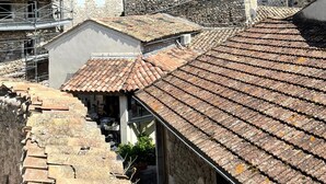 Un pueblo en la ladera con edificios de piedra y una estructura similar a un castillo.