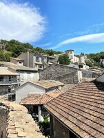 Un pueblo en la ladera con edificios de piedra y una estructura similar a un castillo.