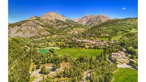 Un paysage montagneux avec un village niché au fond d’une vallée.