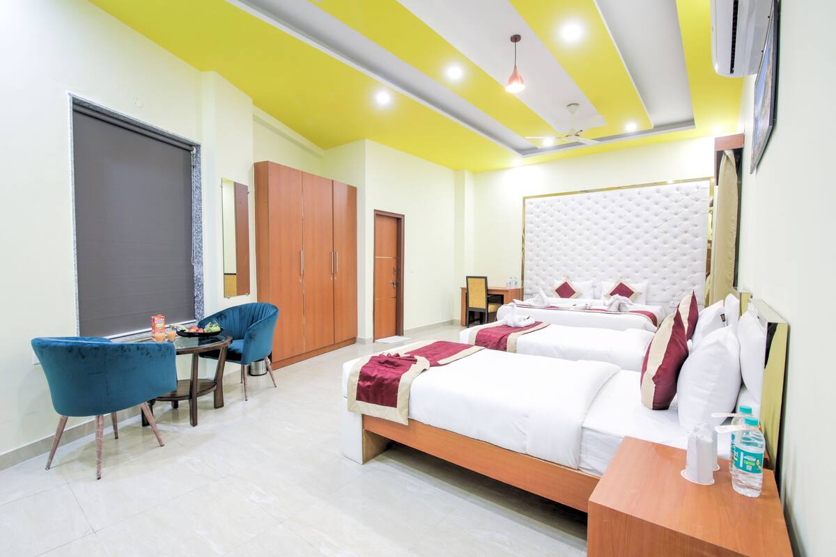 Una habitación de hotel con dos camas, un escritorio, una silla y un armario.