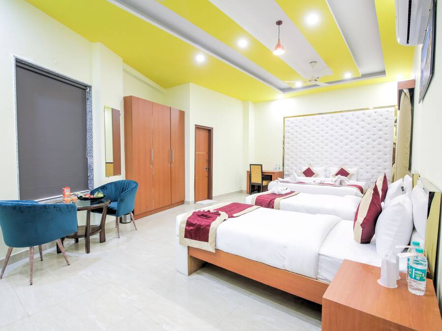 A hotel room with two beds, a desk, a chair, and a wardrobe.