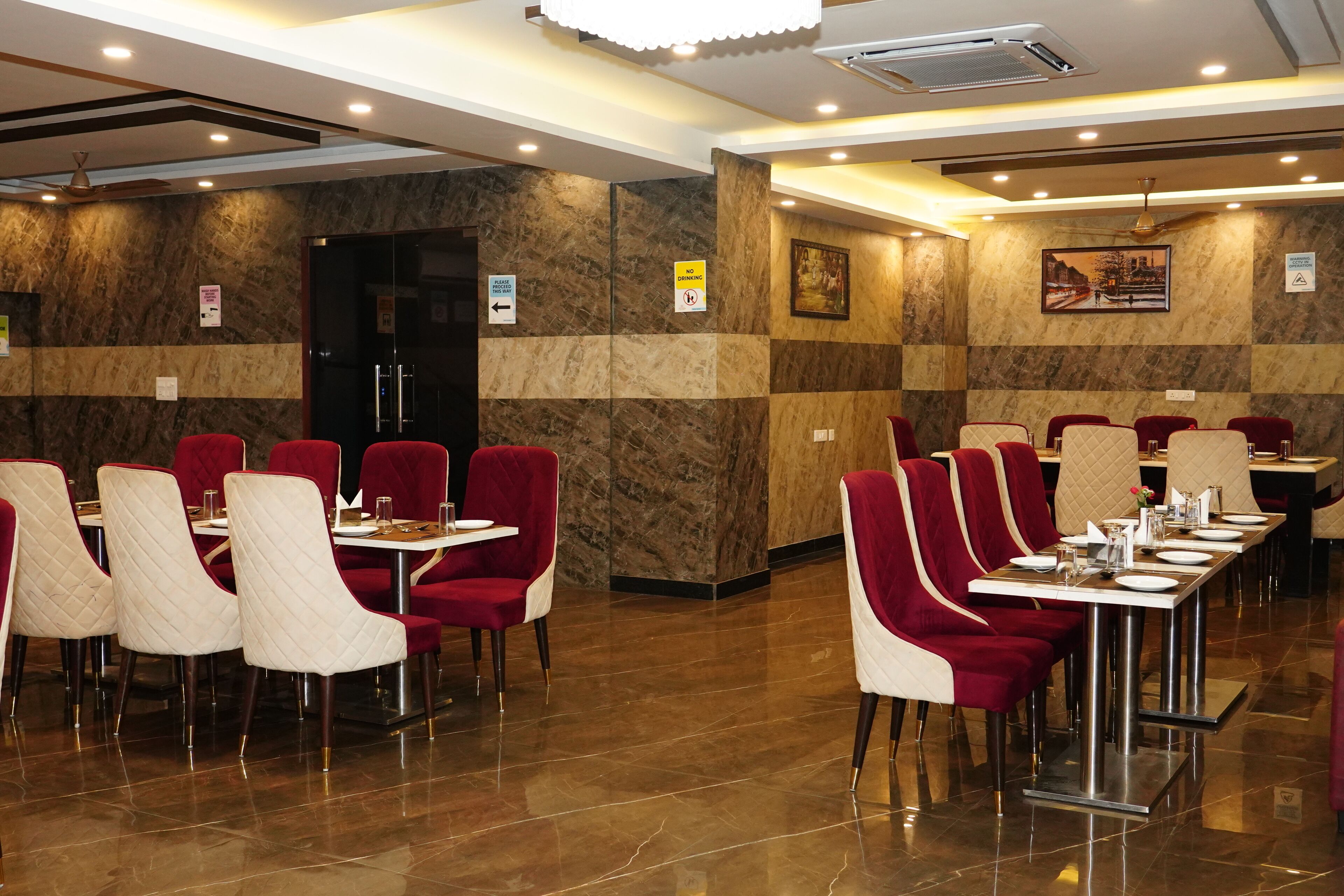 Un restaurante con paredes de mármol, sillas rojas y blancas, y una larga mesa de comedor.
