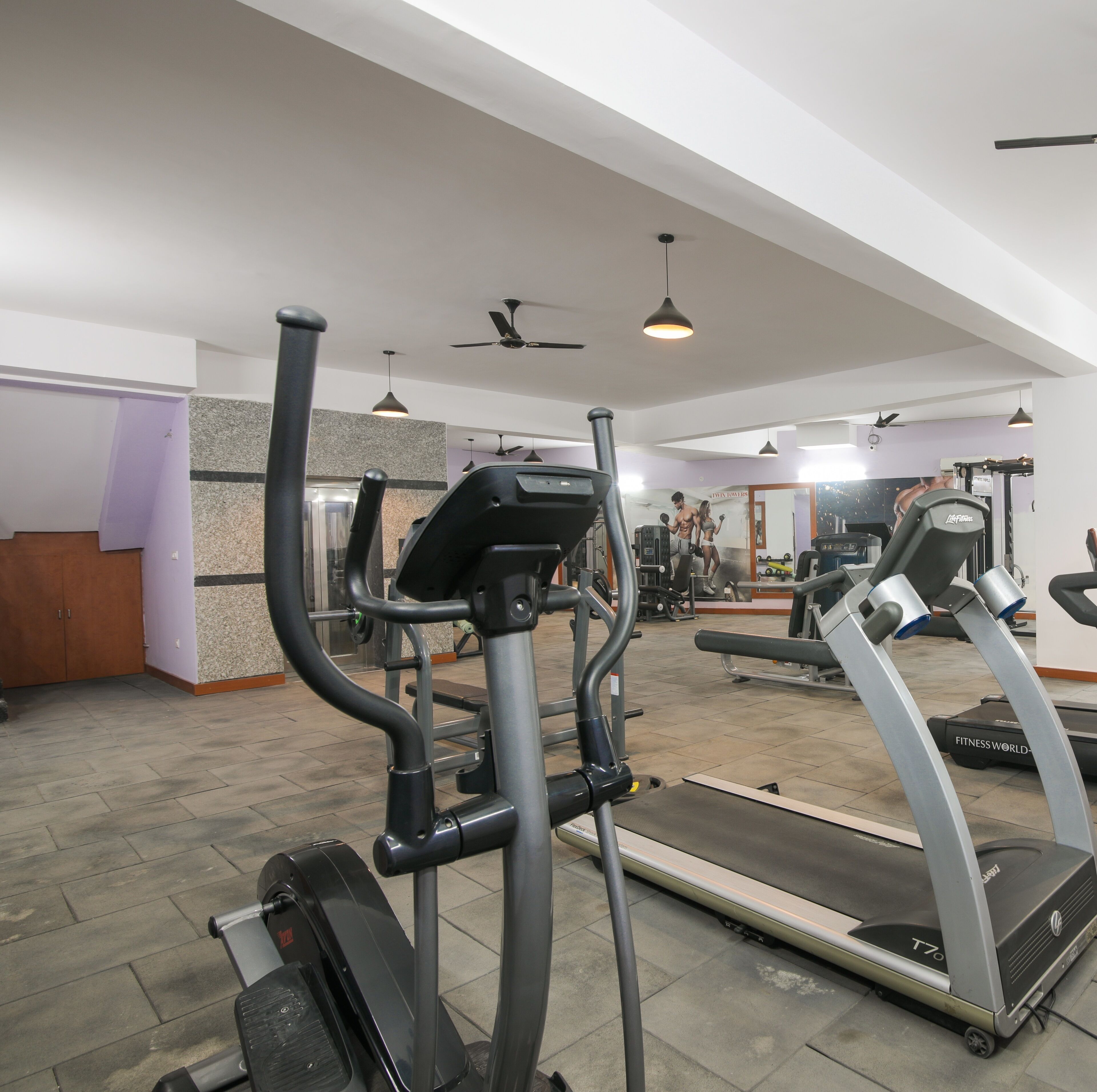 A gym with treadmills, elliptical machines, and weight equipment.