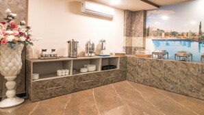 A modern kitchen with marble countertops, a built-in coffee station, and a decorative vase with flowers. - Twin Towers  (Greater Noida)