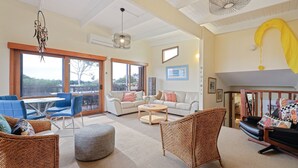Un salon spacieux avec un balcon, une cheminée et une vue sur l’extérieur.