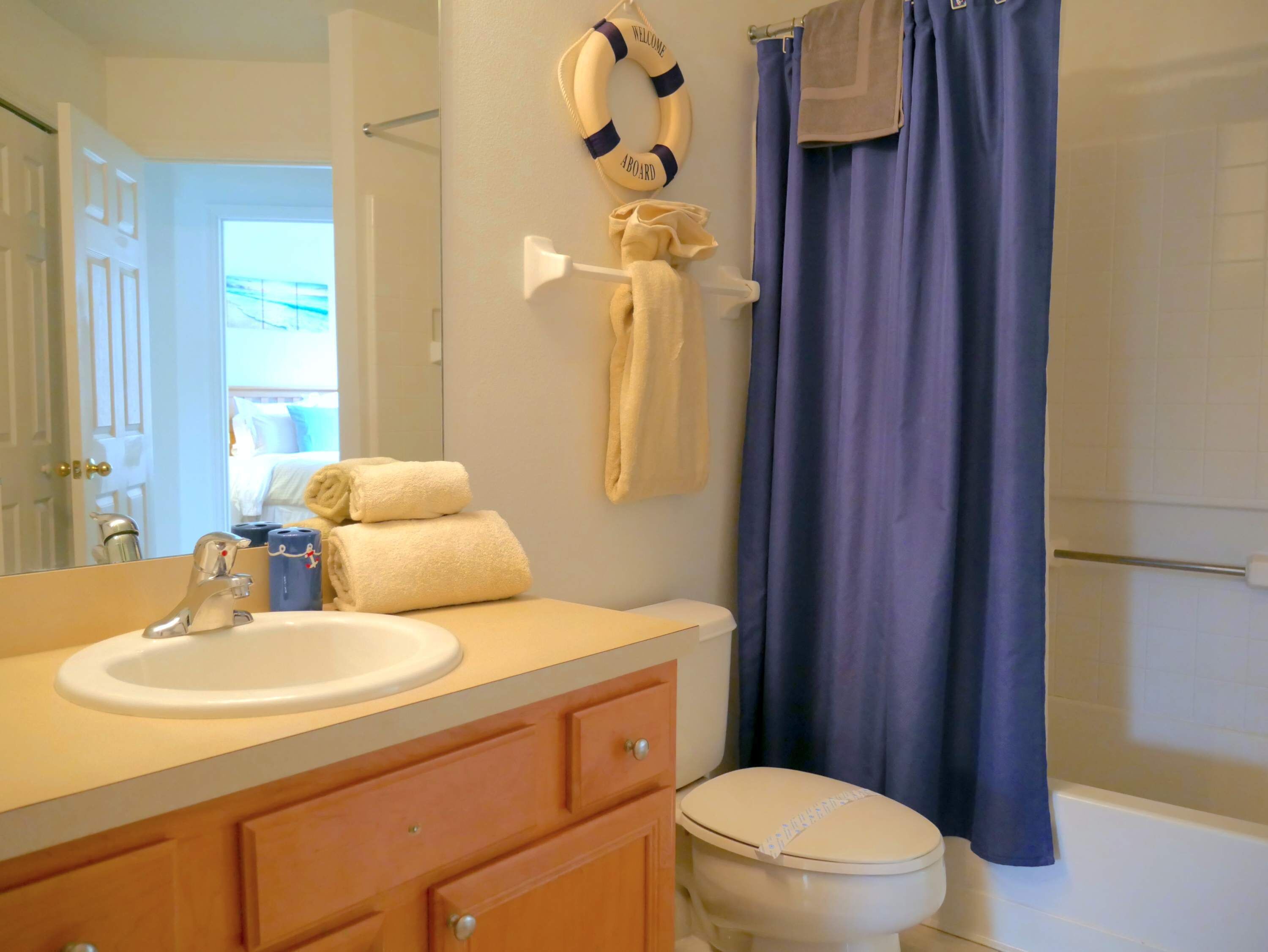 A bathroom with a sink, toilet, and a shower curtain.