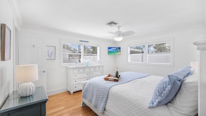 A bedroom with a bed, dresser, nightstand, and a ceiling fan. - Cozy Inland Home | Backyard & Steps to Shopping (Marco Island)