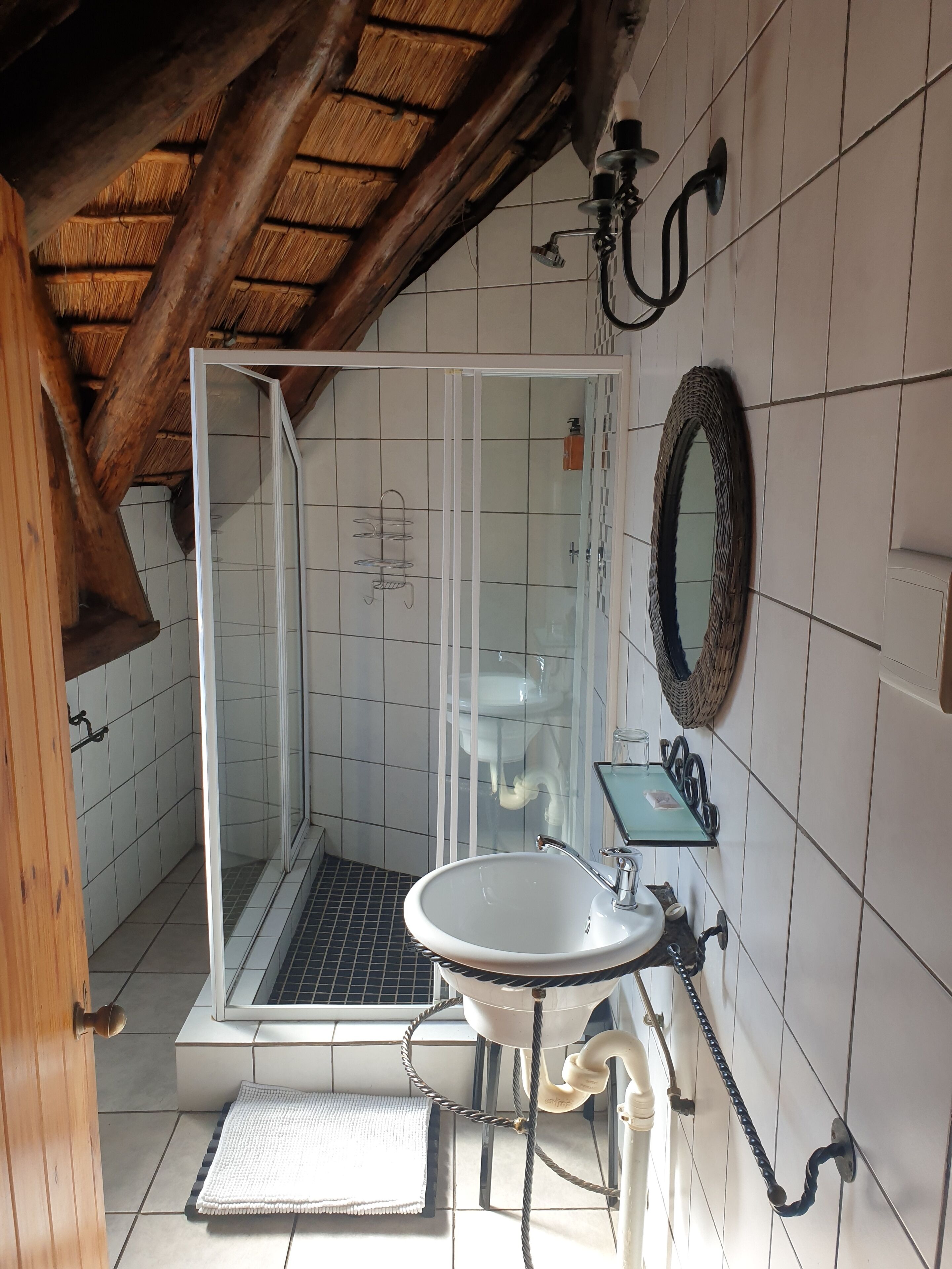 Un baño con ducha, lavabo y espejo.