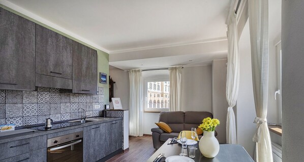 A compact living space with a kitchenette, dining area, and a sofa.