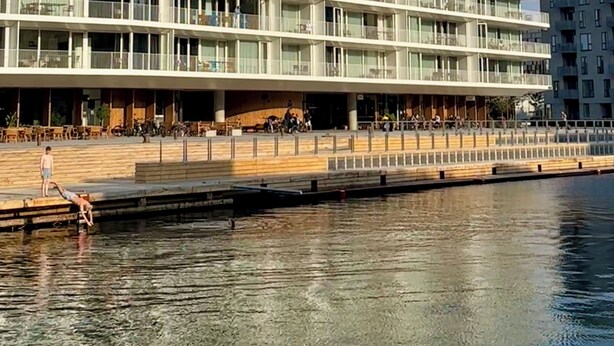 Un moderno hotel de varios pisos con fachada plana, amplias ventanas y ubicación frente al mar.