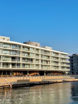 Un moderno hotel de varios pisos con fachada plana, amplias ventanas y ubicación frente al mar.