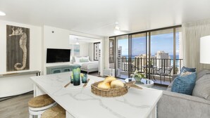 Una sala de estar moderna con un gran ventanal, un comedor con mesa de mármol y un balcón con vistas a la ciudad.