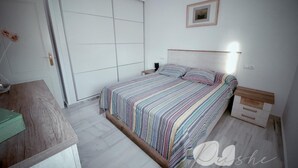 Ein Schlafzimmer mit einem Bett, einem Nachttisch und einem Kleiderschrank.