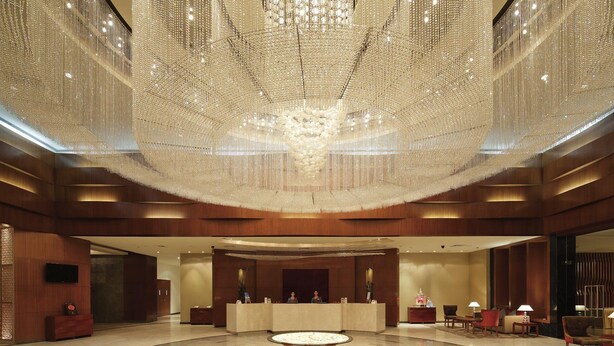 A spacious lobby with a central round table, a reception desk, and a large chandelier. - Yashail Hotel Haridwar (Haridwar)