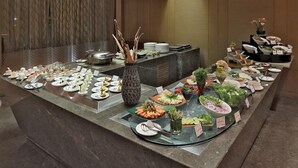 A buffet setup with various dishes and a decorative vase. - Yashail Hotel Haridwar (Haridwar)