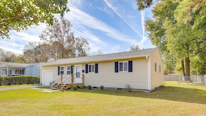 A single-story mobile home with a front porch, a small front yard, and a garage.