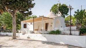 A small white building with a dome and a porch, surrounded by a low wall and trees. - Trullo Bella Vista With Patio & Parking (Locorotondo)