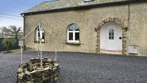 A building with a stone facade, a white door, and a small window. - Instinct - Jacuzzi, Sauna, Apéritif dînatoire et petit déjeuner (Rocquigny)