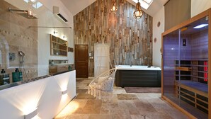 A modern bathroom with a wooden wall, a large bathtub, a glass shower enclosure, and a vanity with a mirror. - Instinct - Jacuzzi, Sauna, Apéritif dînatoire et petit déjeuner (Rocquigny)