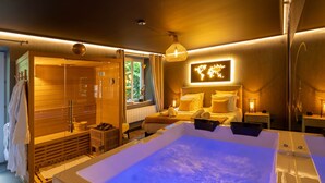 Une salle de spa moderne dotée d’une grande baignoire, d’un sauna en bois et d’un lit orné d’une carte du monde au mur.