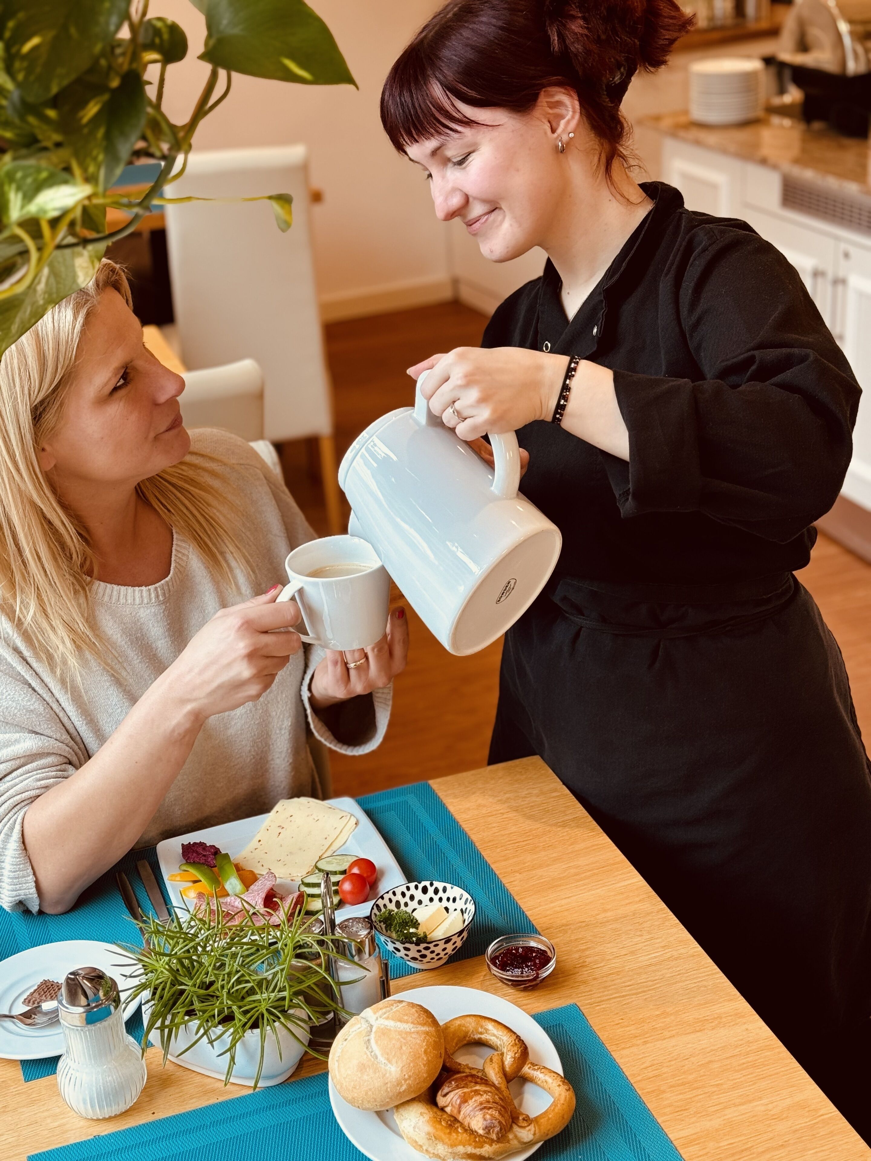 A dining table with a plate of food, a salt shaker, and a pitcher.