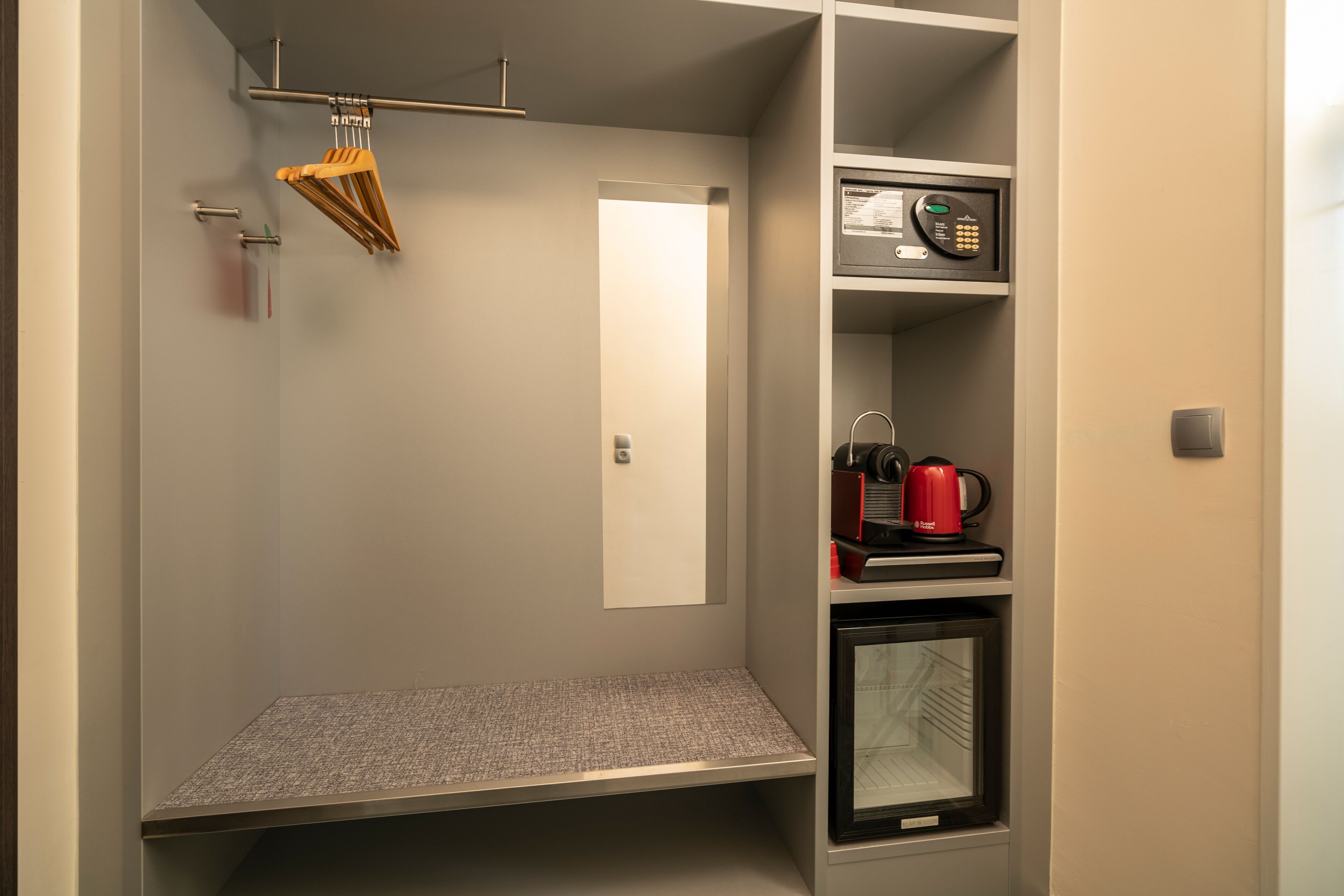 A compact kitchenette with a microwave, coffee maker, and a small refrigerator.