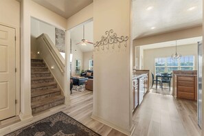 A spacious interior with a staircase leading to a living area, a kitchen with wooden cabinets, and a dining area with a view.