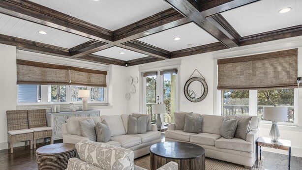 A spacious living room with a high ceiling, large windows, and a fireplace. - NatureWalk Community | 6-Seat LSV (Santa Rosa Beach)