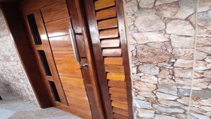 A wooden door with a stone wall adjacent to it.