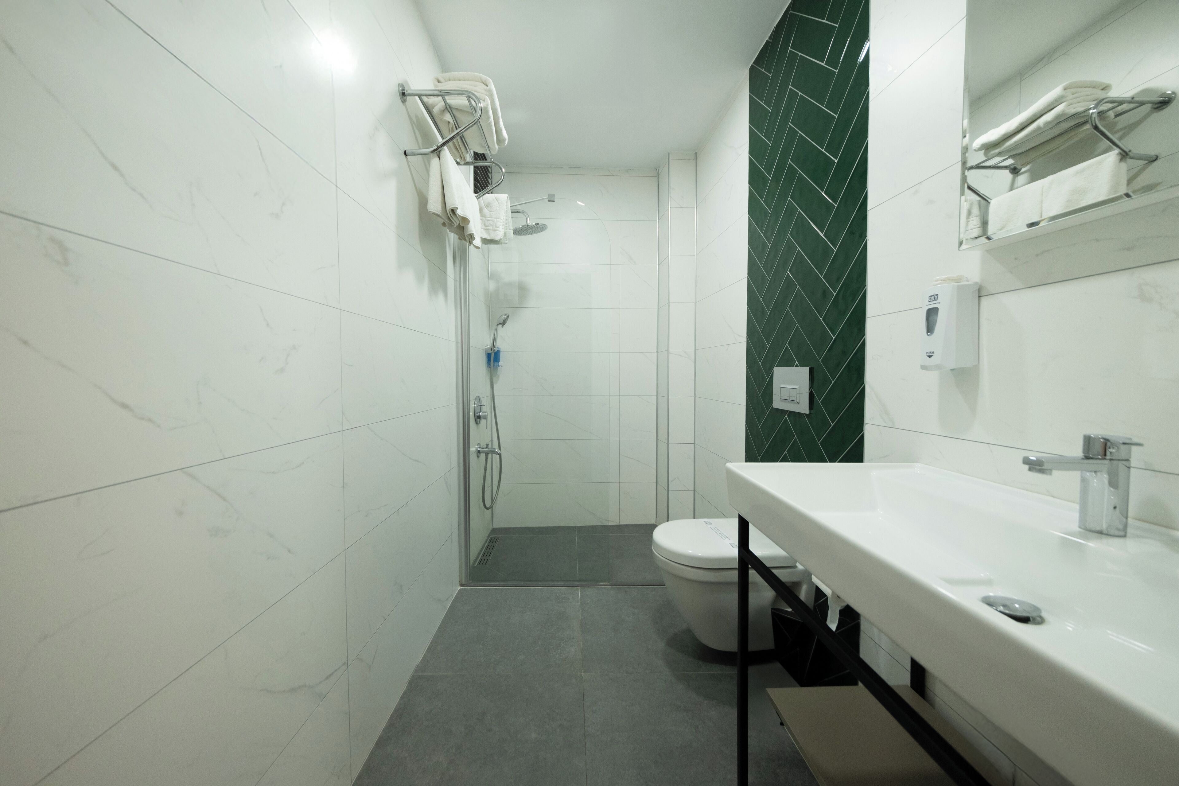 A modern bathroom with a shower, toilet, and sink.
