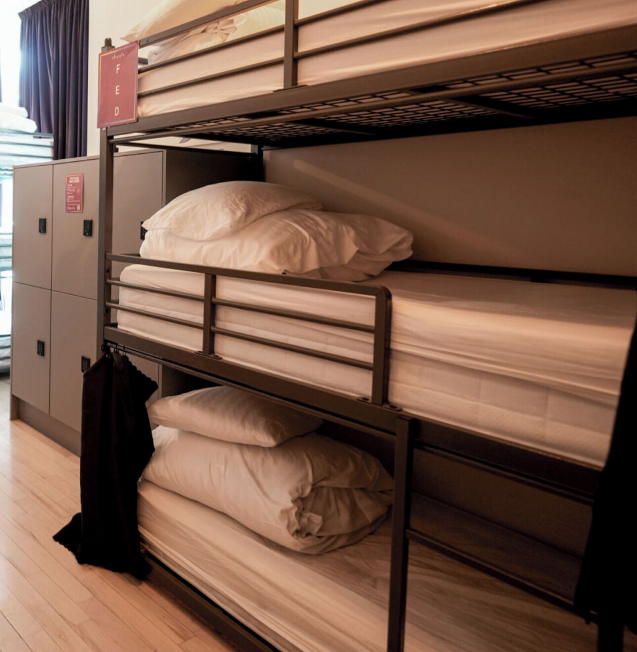 A bunk bed with a storage cabinet and a coat rack.