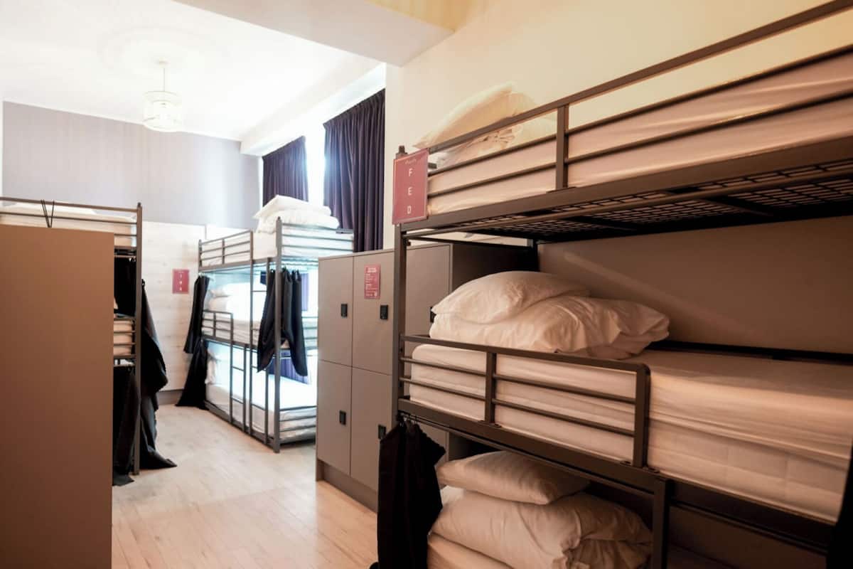 Ein Schlafsaalzimmer mit Etagenbetten, einem Kleiderschrank und einem Schrank.