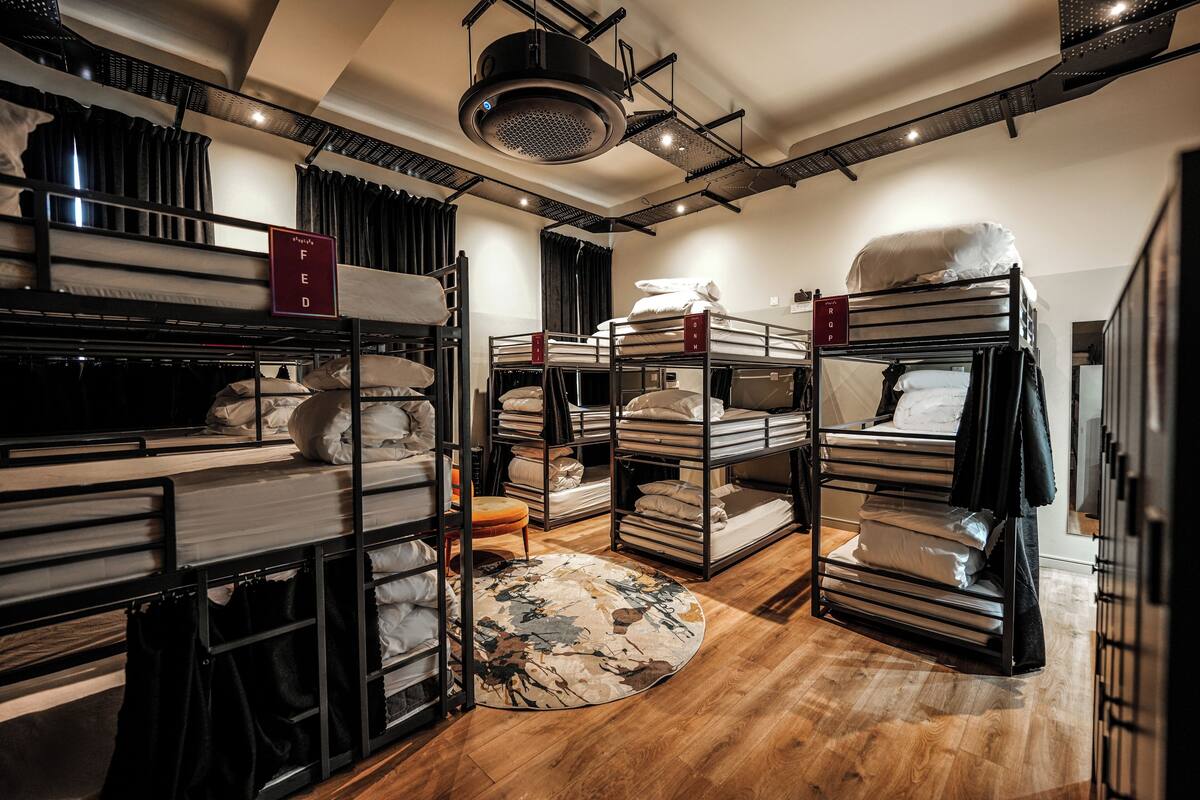 Ein Hotelzimmer mit Etagenbetten, einem runden Teppich und einer Deckenleuchte.