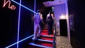 A hotel entrance with a neon sign, a staircase, and a security door. - Revolver Glasgow (Glasgow)