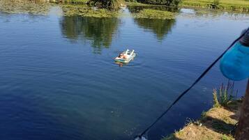 A calm lake with a person floating on a small inflatable raft.